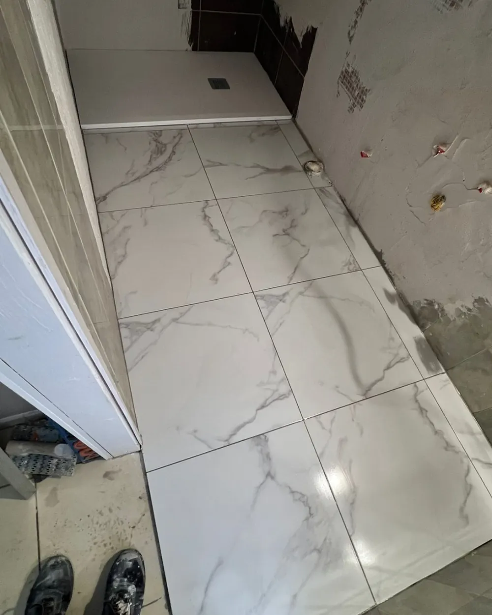 Piatto doccia filo pavimento appena installato accanto al gres effetto marmo