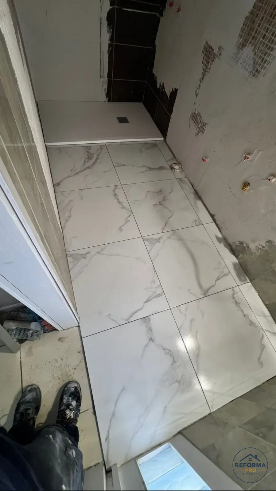 Piatto doccia filo pavimento appena installato accanto al gres effetto marmo