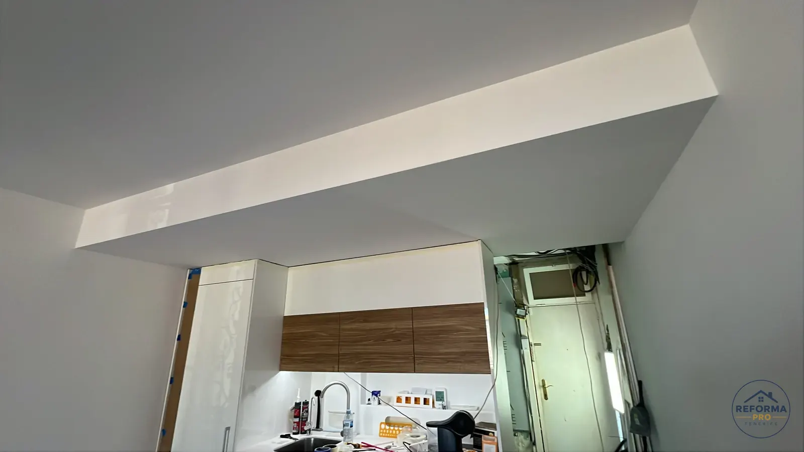Montaggio di cucina bianca e pensili in legno durante il cantiere Montaggio di cucina bianca e pensili in legno durante il cantiere