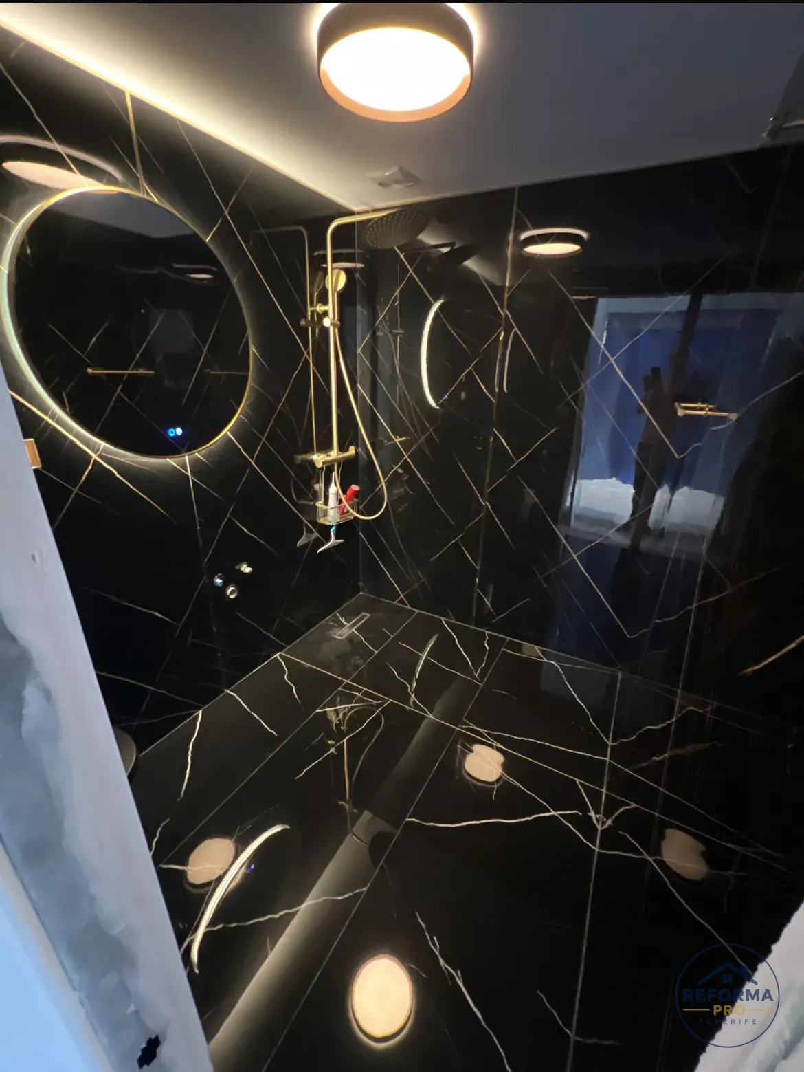 Bagno nero finito con rivestimento effetto marmo, doccia a pioggia e luce integrata
