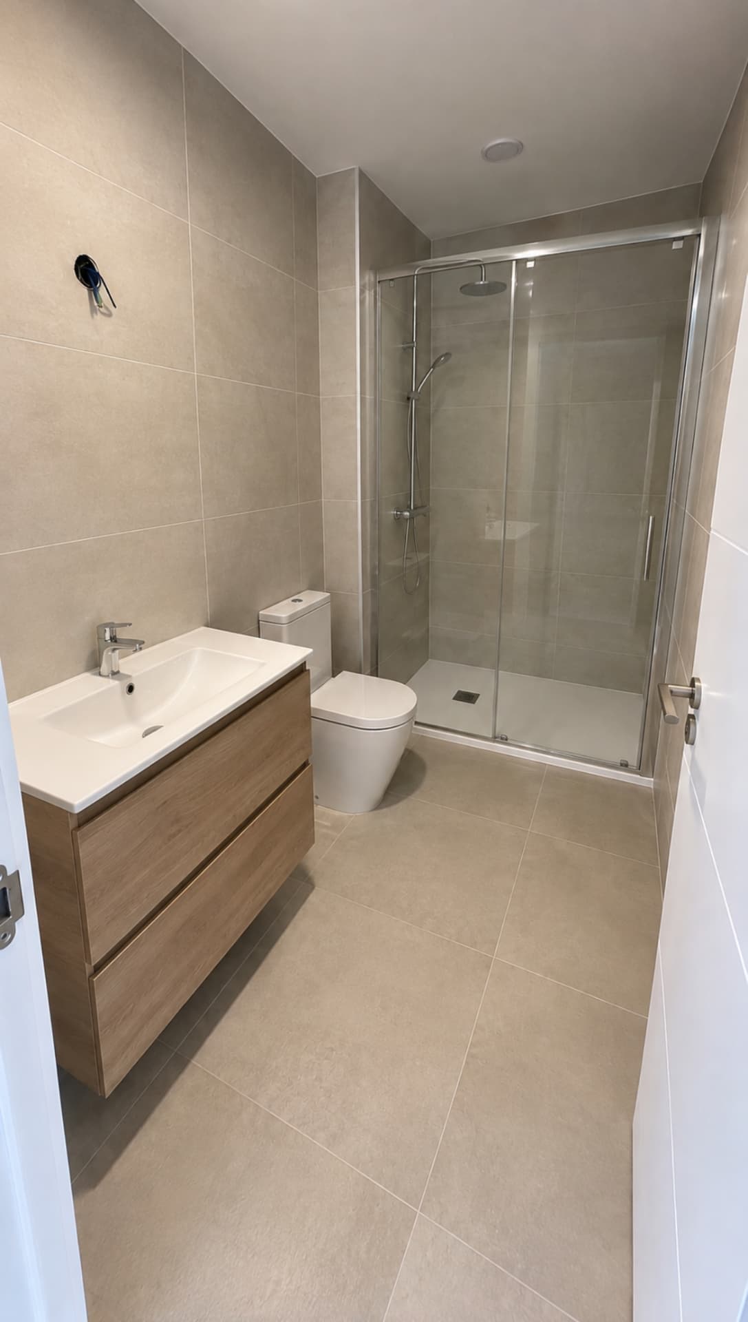 Fertiges beiges Bad mit Dusche und Eichenmöbel Fertiges beiges Bad mit Dusche und Eichenmöbel