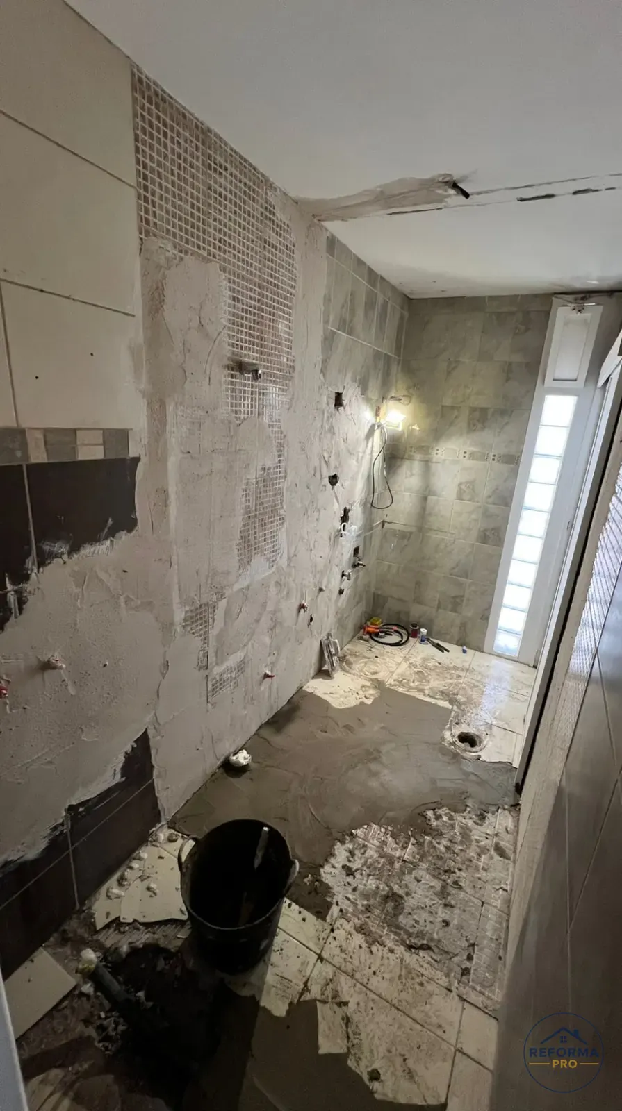 Pareti del bagno spicconate e nuovi impianti idraulici durante la demolizione