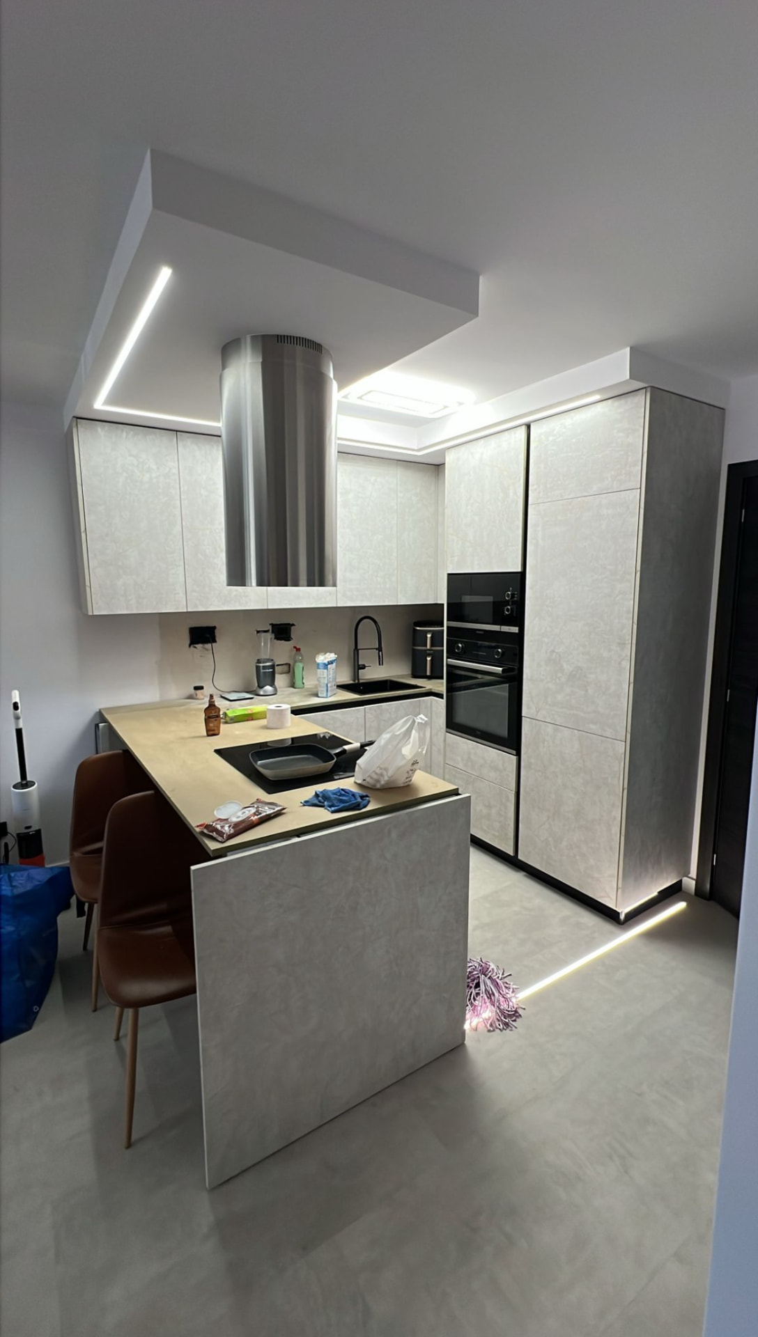 Cucina moderna finita con isola, cappa cilindrica e controsoffitto con luci LED Cucina moderna finita con isola, cappa cilindrica e controsoffitto con luci LED