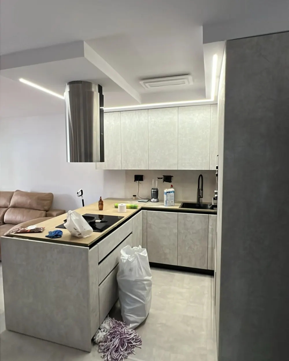 Cucina a U con piano cottura a induzione sull isola e ante effetto cemento