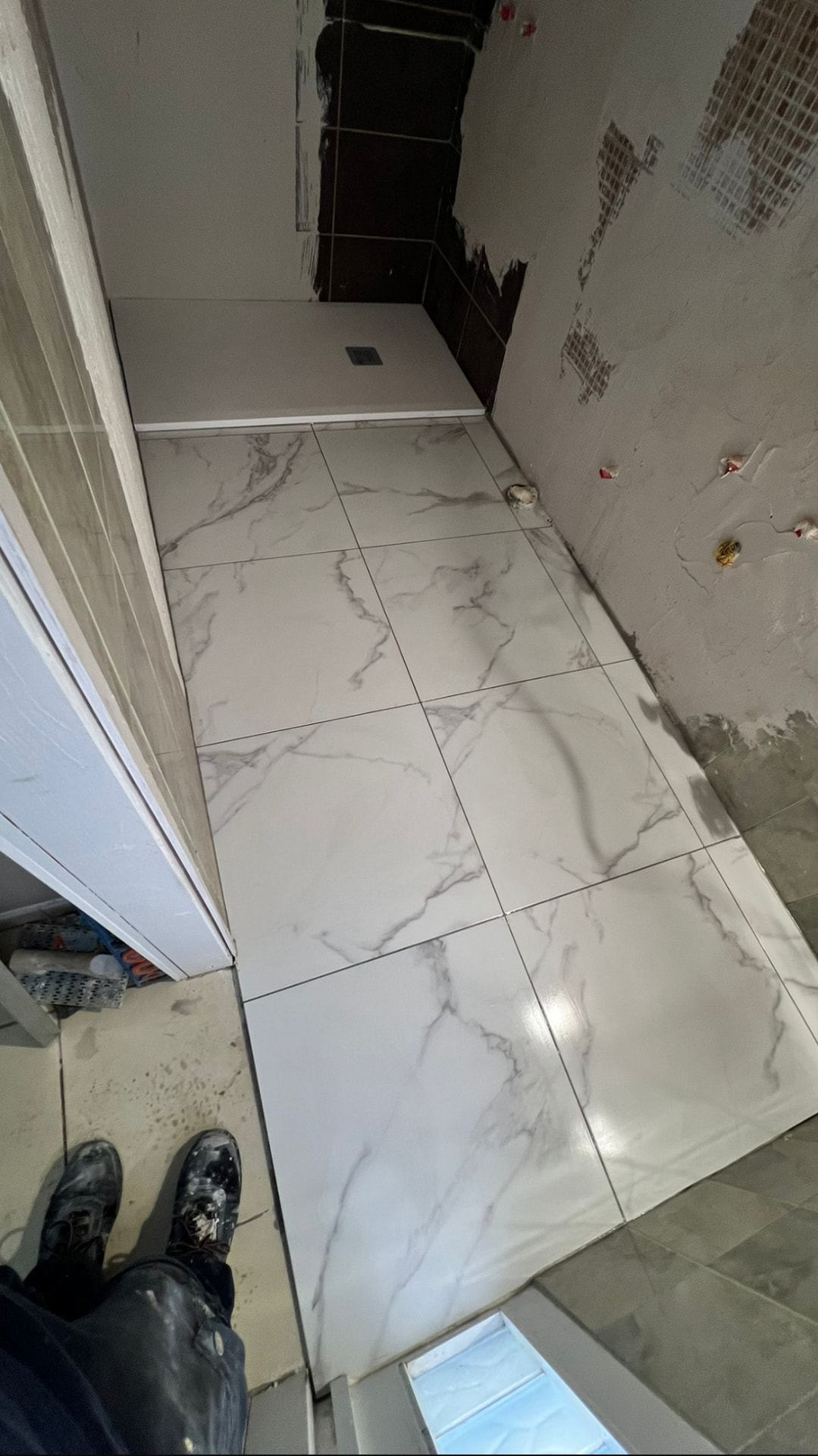 Piatto doccia filo pavimento appena installato accanto al gres effetto marmo